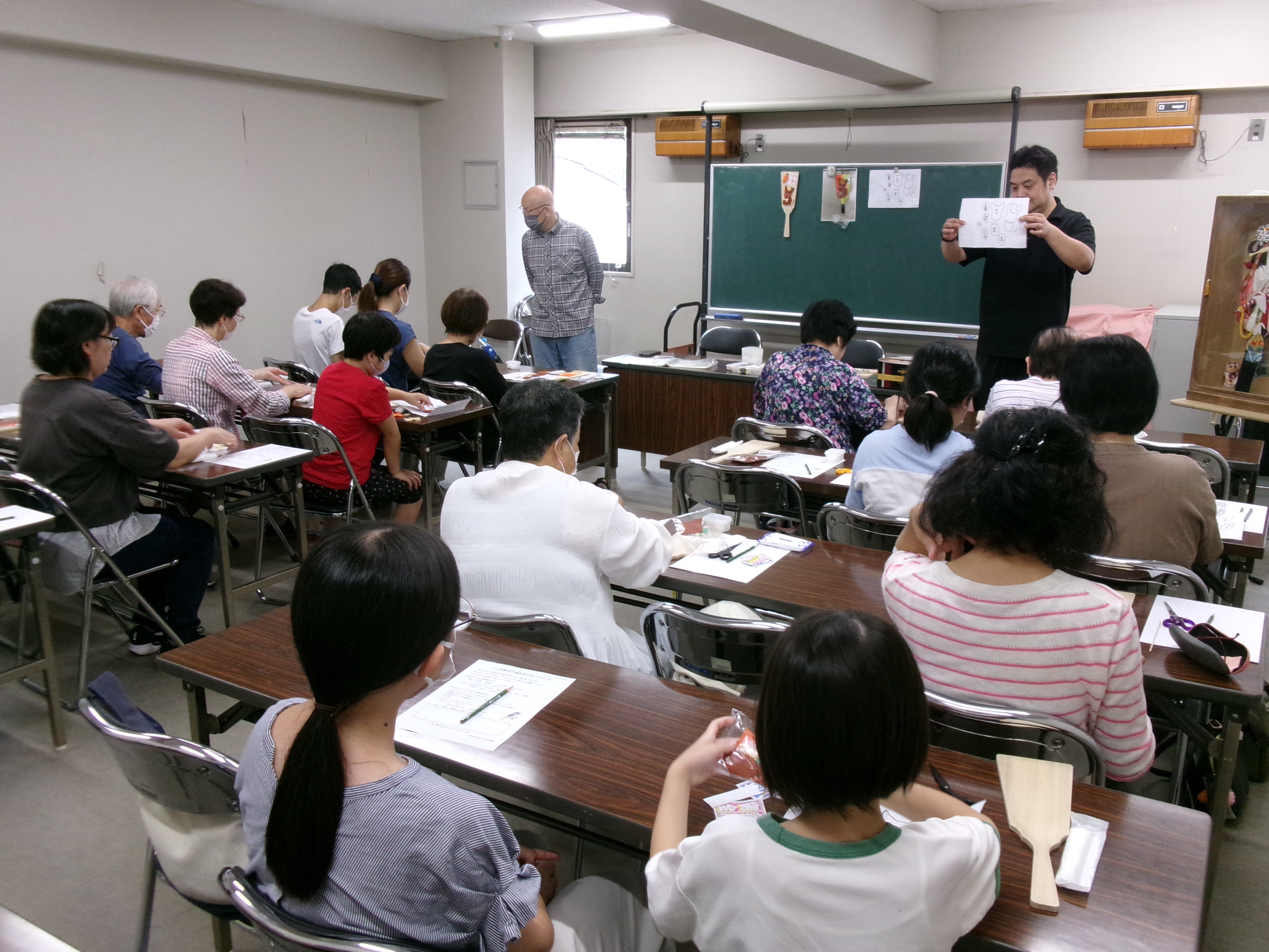 押絵羽子板作成の説明を聞く様子