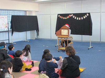 紙芝居『クリスマスのおおきなくつした』を読むスタッフ